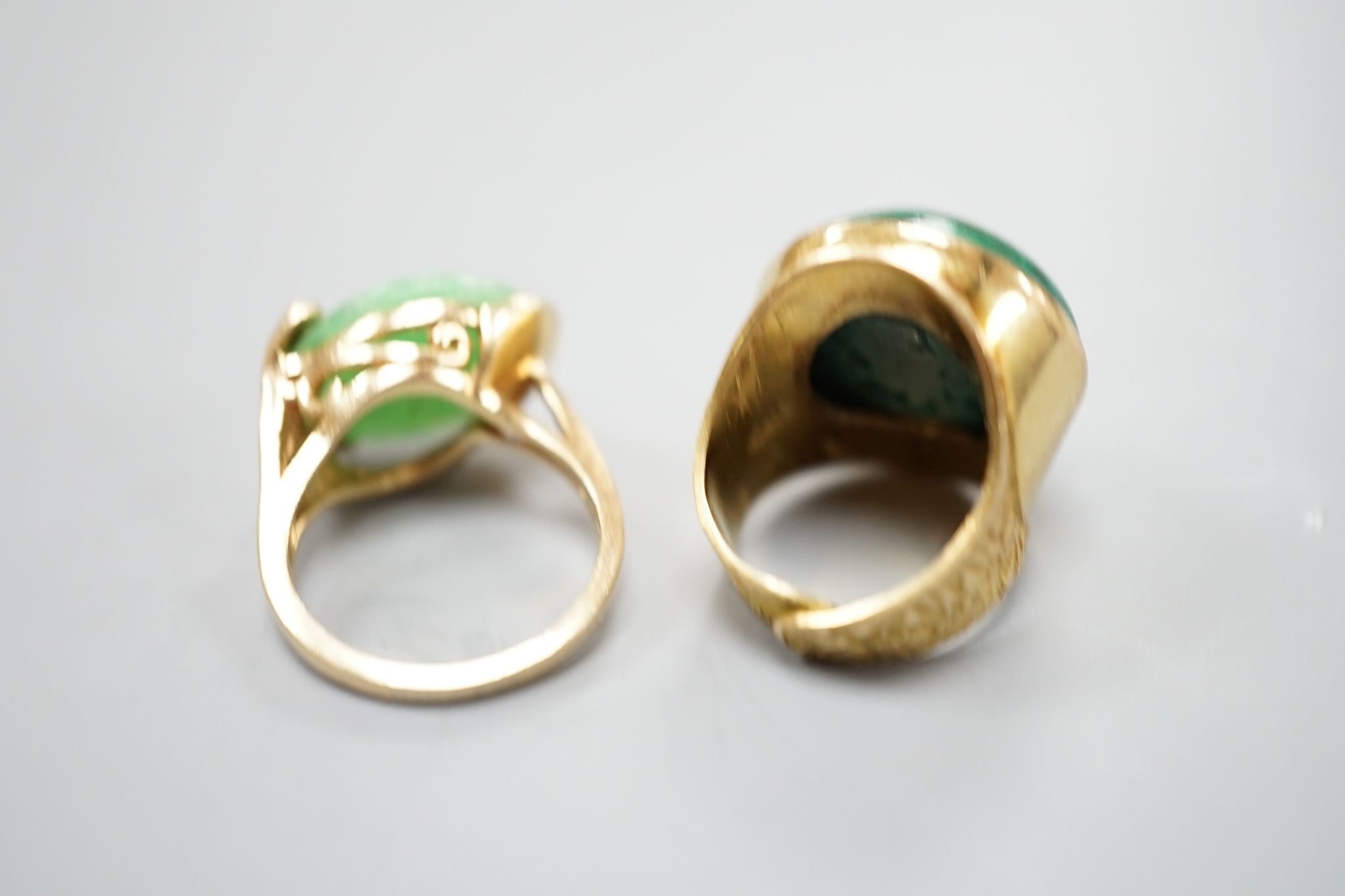 A modern 14k yellow metal and cabochon malachite set dress ring, size F and a similar cabochon jade set ring, size K, gross weight 16.8 grams.